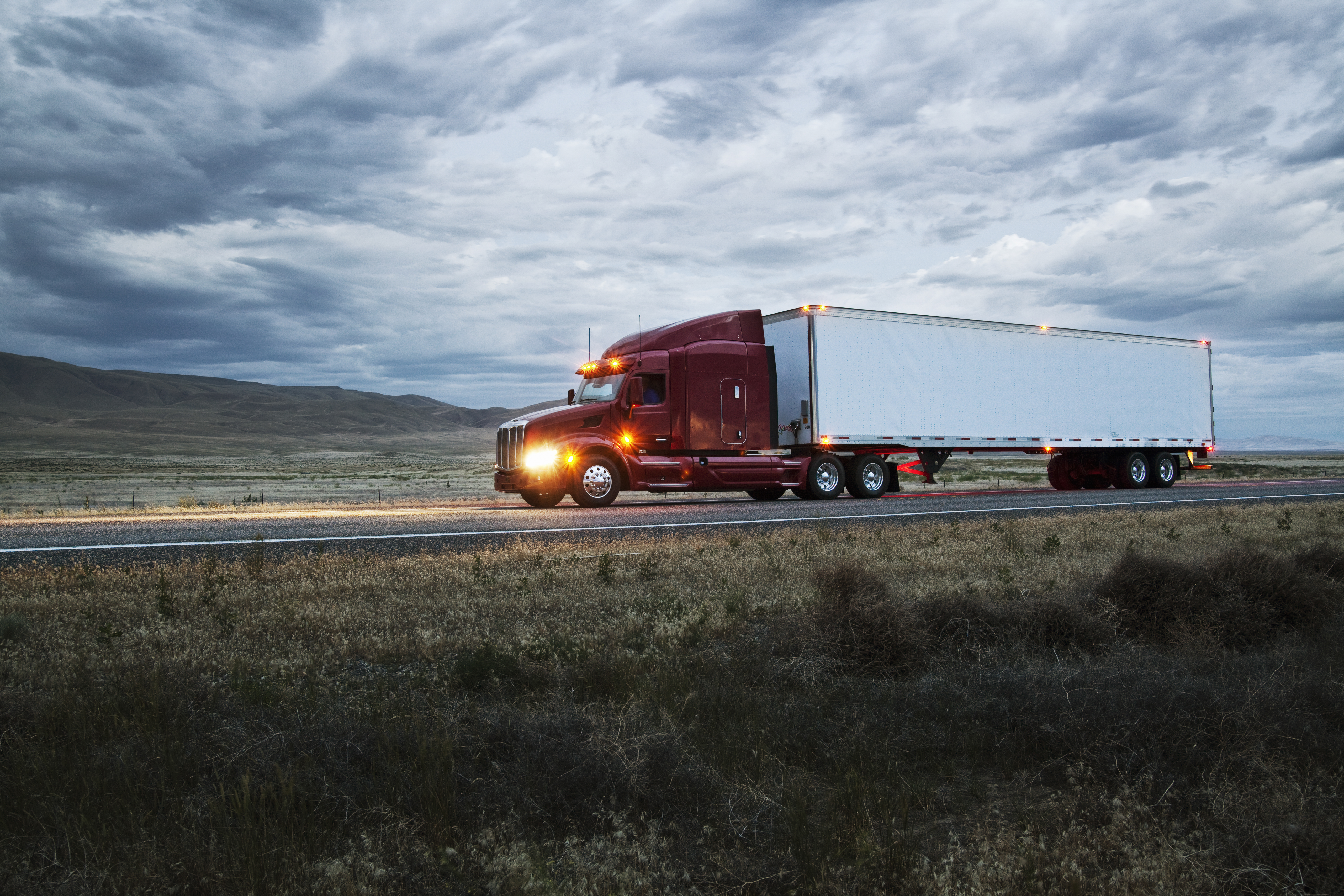 Commercial truck on a highway through open grassland