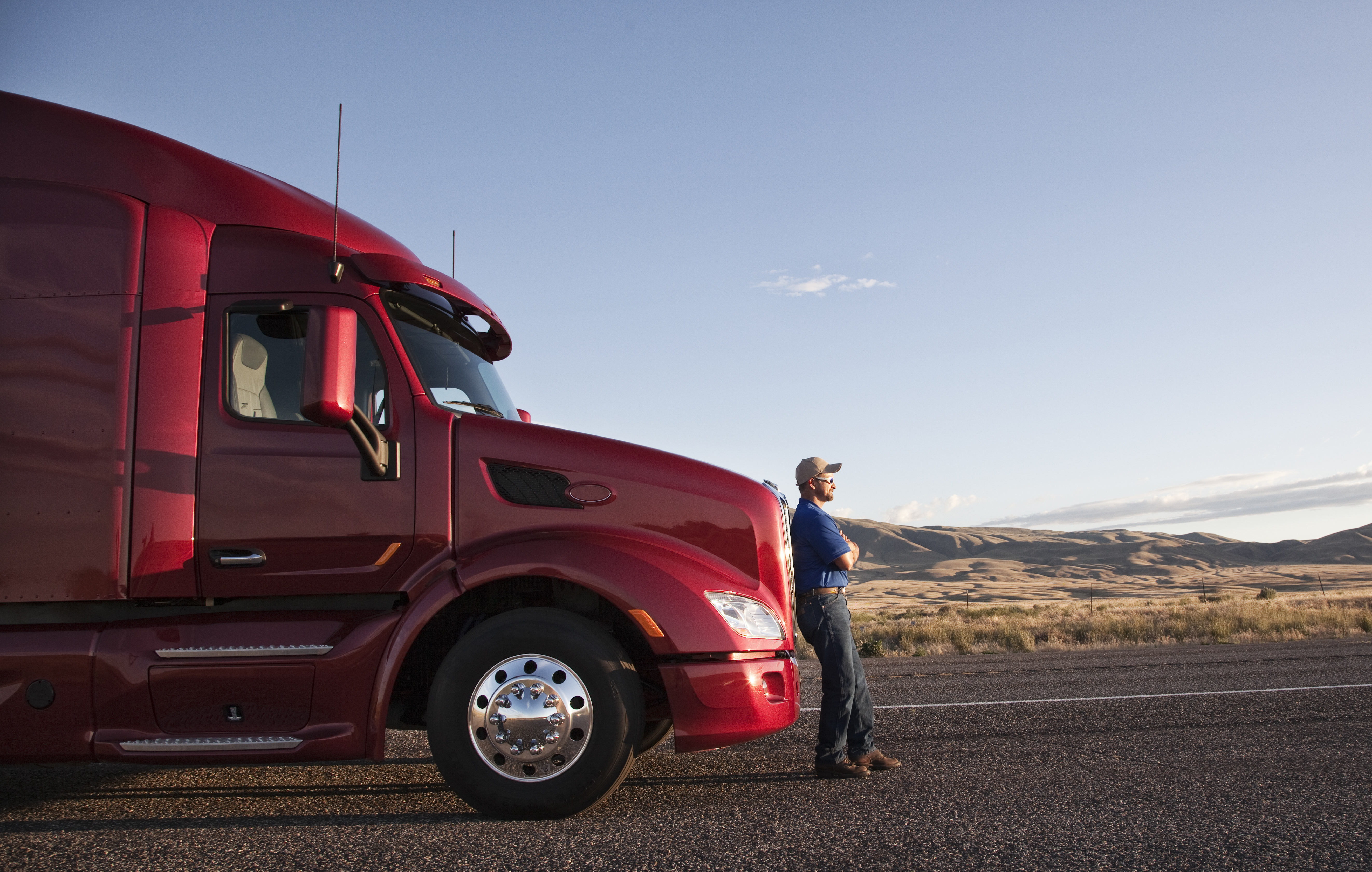 Truck driver standing beside a commercial truck